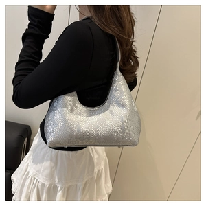 Detailaufnahme der silbernen Schlangenmuster-Textur einer modischen Metallic-Hobo-Tasche