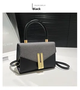Detailed close-up of a modern black and grey textured handbag with elegant gold metal lock