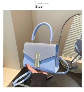 Detail of light blue crossbody bag with woven flap and gold lock in a lifestyle setting