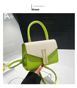 Close-up of green leather and beige tweed crossbody bag with golden metal lock