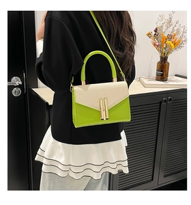 Detail of neon green square bag with textured beige flap and gold metal locks