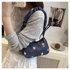 Blue denim underarm bag with pink floral embroidery and ruffled scrunchie strap