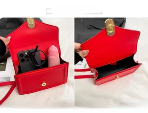 Vue intérieure montrant la grande capacité du sac à bandoulière rouge avec accessoires