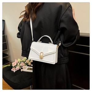 White faux leather crossbody bag with gold lock shown on model for size perspective