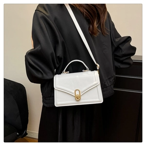 Détail du sac à bandoulière blanc avec fermoir tournant doré et coutures élégantes