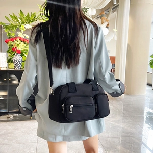 Minimalist black Boston bag in waterproof fabric shown on a model for daily use