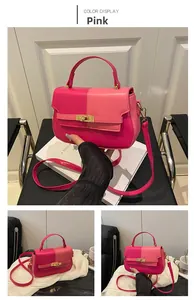 Detail view of pink two-tone fashion satchel with golden clasp and top handle
