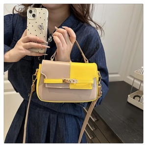 Macro detail of color-block saddle bag featuring yellow accents and metal swivel lock