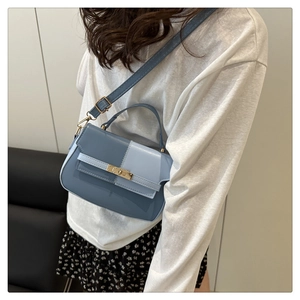 Detail of color-block Kelly bag in blue PU leather worn as a stylish crossbody bag