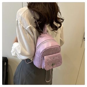 Détail d'un mini sac à dos matelassé lavande avec rivets argentés et bandoulières chaîne