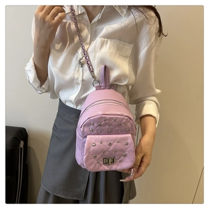 Détail d'un mini sac à dos matelassé lilas avec strass et bandoulière chaîne sur modèle
