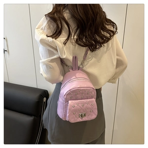 Vue arrière d'un mini sac à dos violet matelassé avec des rivets argentés sur un mannequin