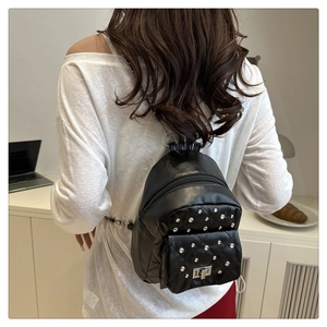 Schicker schwarzer Mini-Rucksack mit Steppmuster, Nieten und Kettenriemen am Model