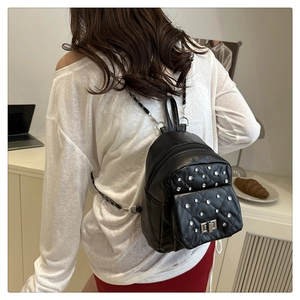 Détail du mini sac à dos noir matelassé avec strass brillants et bandoulière en chaîne