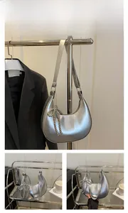 Détails du sac demi-lune argenté avec charm nœud perlé et logo fashion chic