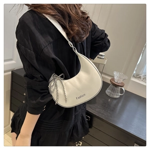 Chic white croissant bag with pearl bow charm and 'Fashion' text on shoulder