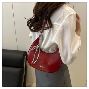 Detail of red crescent leather bag with silver butterfly chain and Fashion print