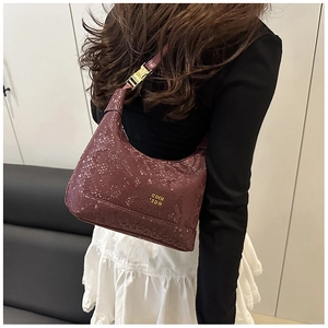 Close-up of burgundy snake-pattern leather handbag with golden hardware and buckle