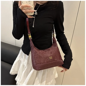 Detail of dark red snake pattern shoulder bag with golden logo and adjustable strap
