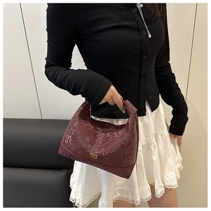 Détails de texture serpent bordeaux sur un sac à main chic avec logo doré brillant