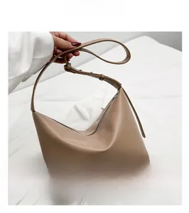 Détail du sac fourre-tout en cuir beige avec bandoulière fine et fermeture éclair
