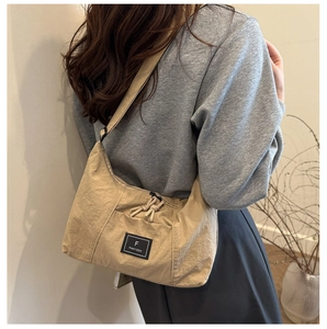 Detail of khaki nylon crescent bag with brand label and unique pleated texture