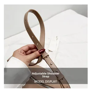 Détail de la bandoulière réglable en cuir avec boucle argentée et couture soignée