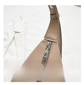 Gros plan d'un sac cabas en cuir kaki avec fermeture éclair argentée et sangle renforcée
