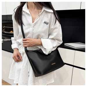 Détail du sac cabas en cuir noir avec lettrage doré et bandoulière réglable
