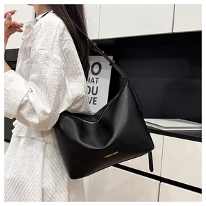 Gros plan d'un sac cabas en cuir PU noir avec logo doré et fermeture éclair métallique robuste