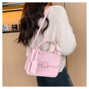 Detail of pink PU leather handbag with decorative square buckle and fashion tag