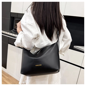Vue détaillée d'un grand sac bandoulière noir porté par un mannequin en mode décontracté