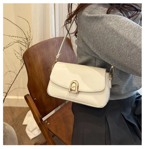 Vue détaillée du sac porté épaule en cuir blanc avec une boucle dorée arquée unique