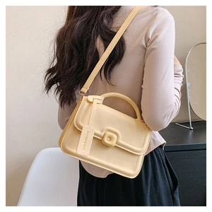 Detail view of cream yellow PU leather handbag with adjustable strap and fashion tag
