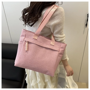 Detail of pink striped tote bag showing woven zipper pull and side pocket for women