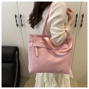 Detail of pink woven tote bag showing fine texture and dual straps in a lifestyle setting