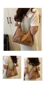 Detail view of woven brown tote bag featuring an angled zipper pocket and shoulder strap