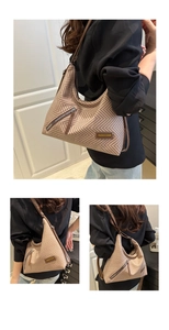 Detail of woven brown hobo bag with chevron pattern and long tassel zipper accent
