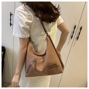 Detalle del bolso tote retro con diseño de espiga y bolsillo lateral con cremallera