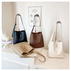Detail view of large capacity minimalist bucket bags in four neutral colors with gold clasp