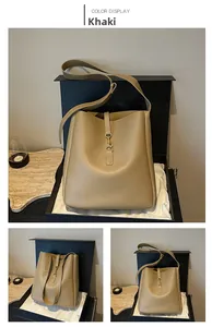 Close-up of khaki leather bucket bag with golden metal buckle in a luxury gift box