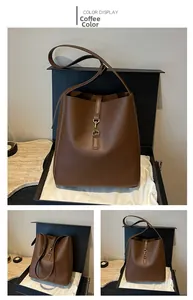 Macro detail of a coffee brown leather bucket bag featuring a gold metal buckle closure