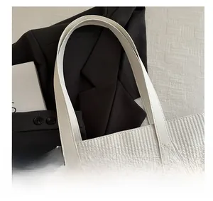 Detail of white woven tote bag showing tight cross-braided texture and smooth PU handle