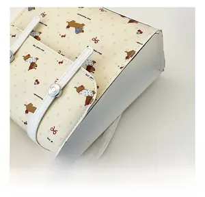 Gros plan des coutures fines et de l'imprimé chiot mignon sur un sac en similicuir beige