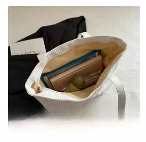 Detail shot of large capacity tote bag interior with tablet, books, and umbrella