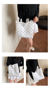 Close-up of white floral canvas bag with lace trim and black shoulder strap detail
