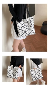 Detailed lace trim and black floral patterns on white canvas shoulder bag for daily wear