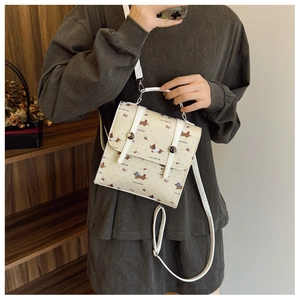 Détail du mini sac à dos beige avec imprimé teckel, sangles en cuir et boucles magnétiques