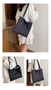 Detail of floral black tote bag with white lace trim and minimalist shoulder strap design