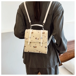 Détail d'un mini sac à dos jaune avec motifs de teckels et cerises porté au dos